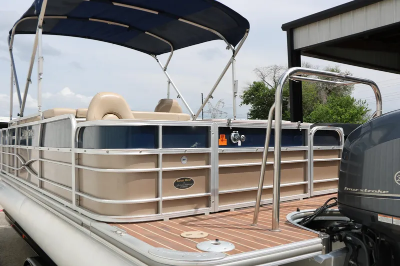 Slide: The Image of 2014 Xcursion X23F pontoon boat with canopy and four-stroke engine, docked outdoors. - 9