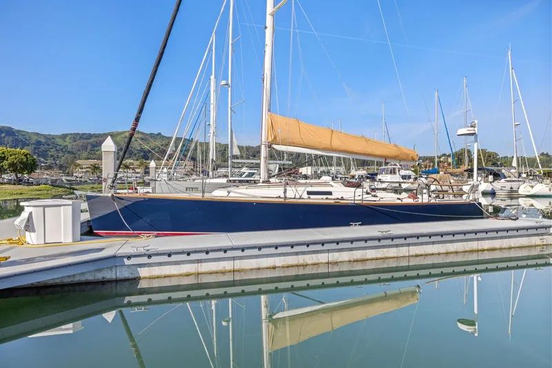 Slide: The Image of 2005 J Boats J/124 sailboat docked in a marina, reflecting on calm water. - 10