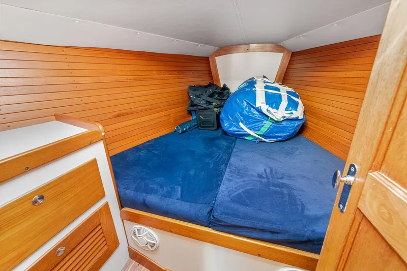Slide: The Image of Cozy cabin interior of 2005 J Boats J/124 with wooden paneling and blue bedding. - 13