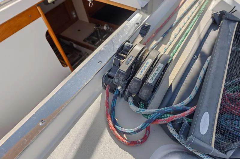 Slide: The Image of Deck view of a 2005 J Boats J/124 sailboat, featuring colorful ropes and cleats. - 17
