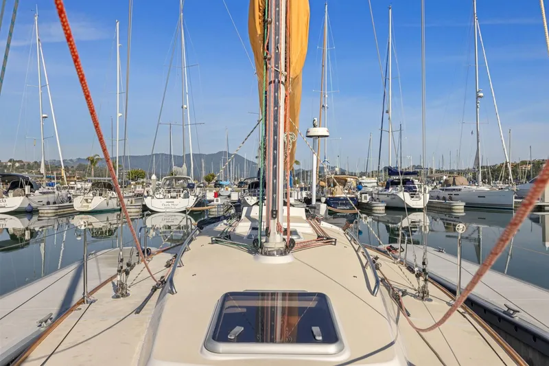 Slide: The Image of 2005 J Boats J/124 sailboat docked in a marina, surrounded by other vessels. - 18