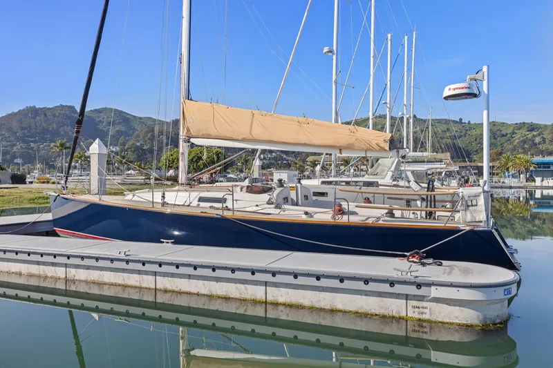 Slide: The Image of 2005 J Boats J/124 sailboat docked in a marina with scenic background. - 2