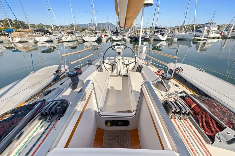 Slide: The Image of 2005 J Boats J/124 sailboat cockpit in marina, showcasing rigging and steering wheel. - 26