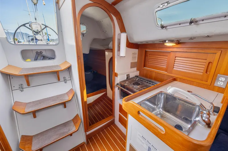 Slide: The Image of Interior of 2005 J Boats J/124 sailboat featuring compact kitchen and wooden steps. - 29