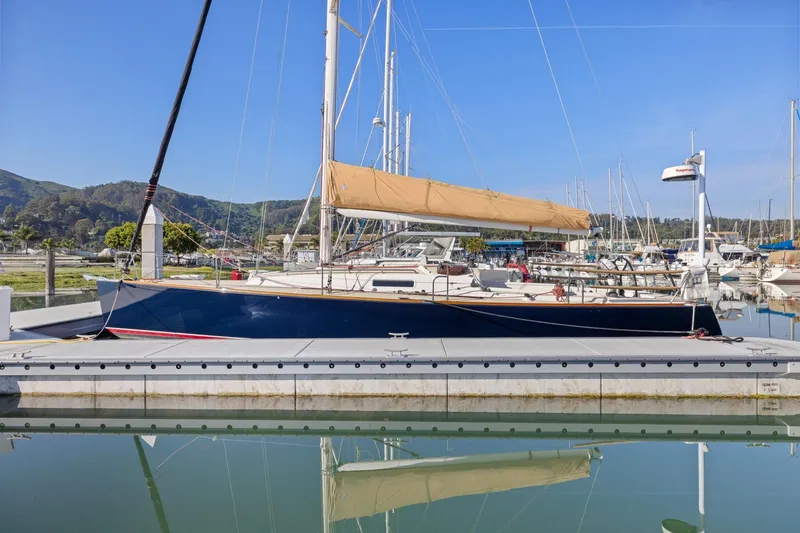 Slide: The Image of 2005 J Boats J/124 sailboat docked in a marina, reflecting on calm water. - 3