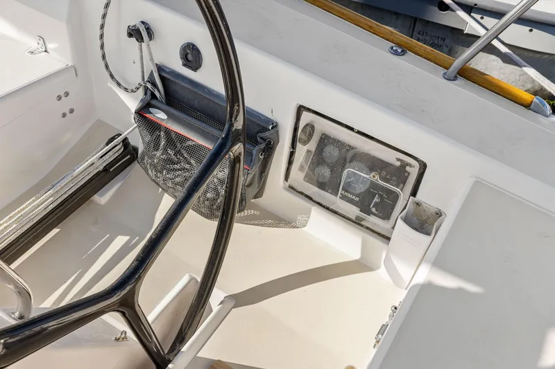 Slide: The Image of Cockpit of 2005 J Boats J/124 sailboat, featuring steering wheel and control panel. - 32