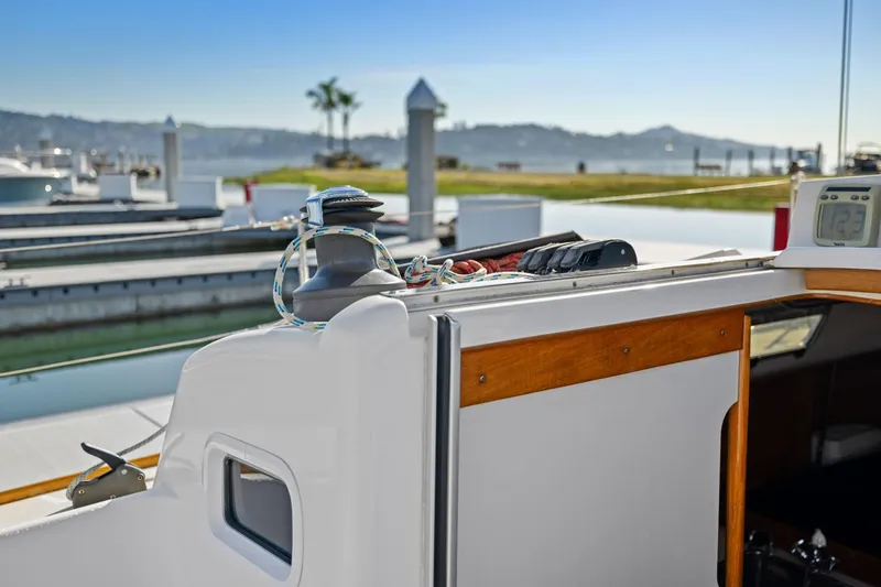Slide: The Image of 2005 J Boats J/124 sailboat cockpit with winch and control panel, docked at marina. - 34