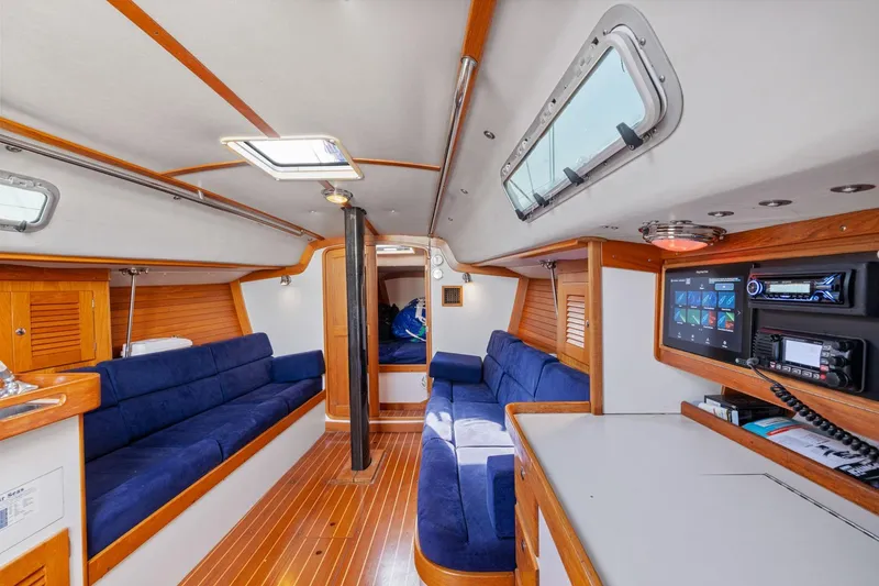 Slide: The Image of Interior of 2005 J Boats J/124 sailboat with blue seating and wooden accents. - 36