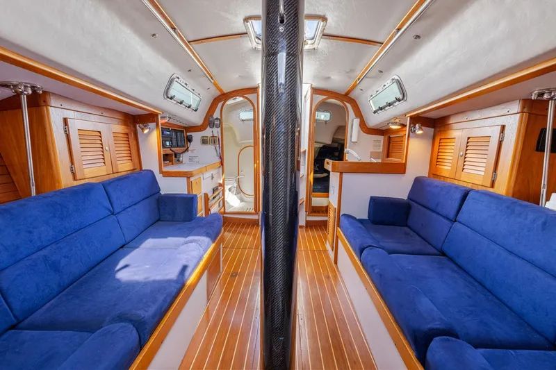 Slide: The Image of Interior of 2005 J Boats J/124 sailboat with blue seating and wooden finishes. - 38