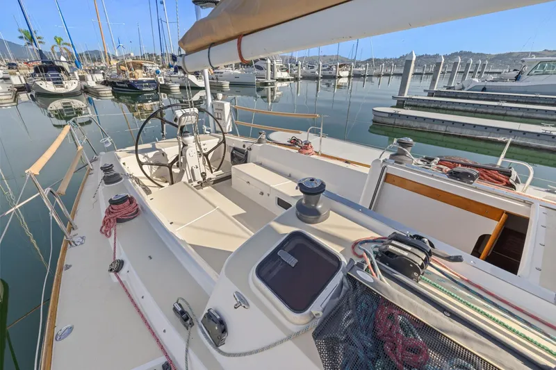 Slide: The Image of 2005 J Boats J/124 sailboat docked in a marina, showcasing its deck and steering wheel. - 5