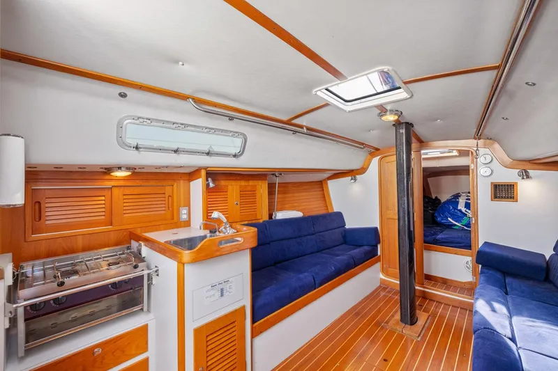 Slide: The Image of Interior of 2005 J Boats J/124 sailboat with wood finish and blue seating. - 6