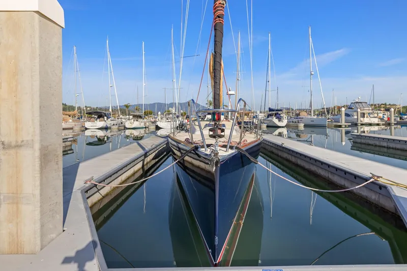 Slide: The Image of 2005 J Boats J/124 sailboat docked in a marina, surrounded by other vessels. - 7