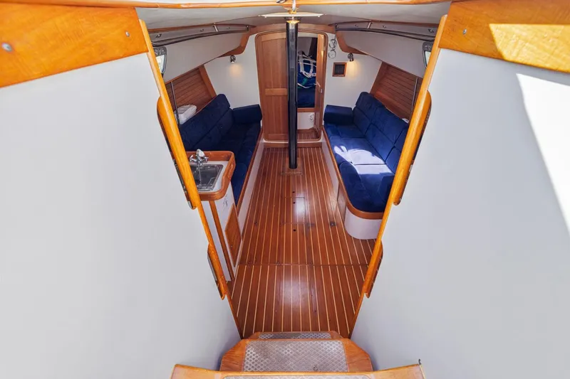 Slide: The Image of Interior of 2005 J Boats J/124 sailboat with wooden flooring and blue seating. - 9