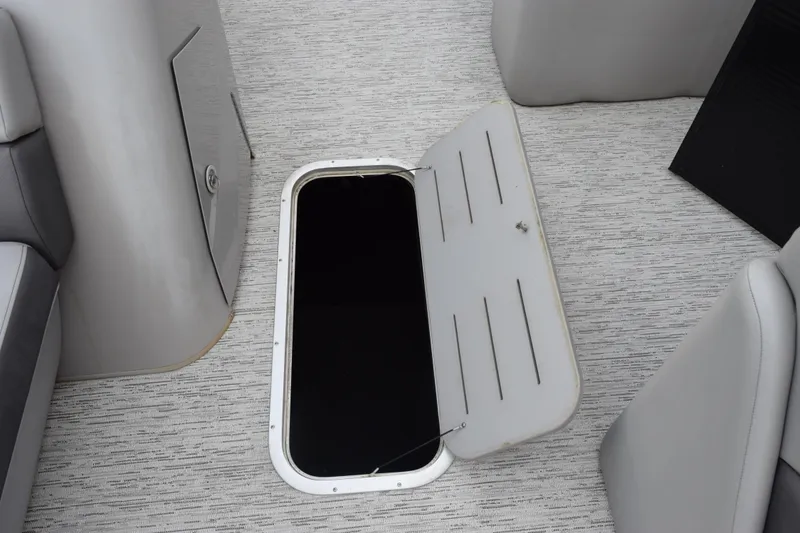 Slide: The Image of Open storage compartment on 2021 Bennington 24 SSBX boat, featuring gray interior design. - 14
