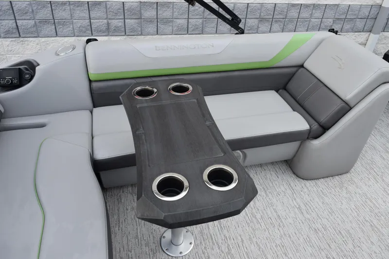 Slide: The Image of 2021 Bennington 24 SSBX boat interior with gray seating and a table with cup holders. - 8