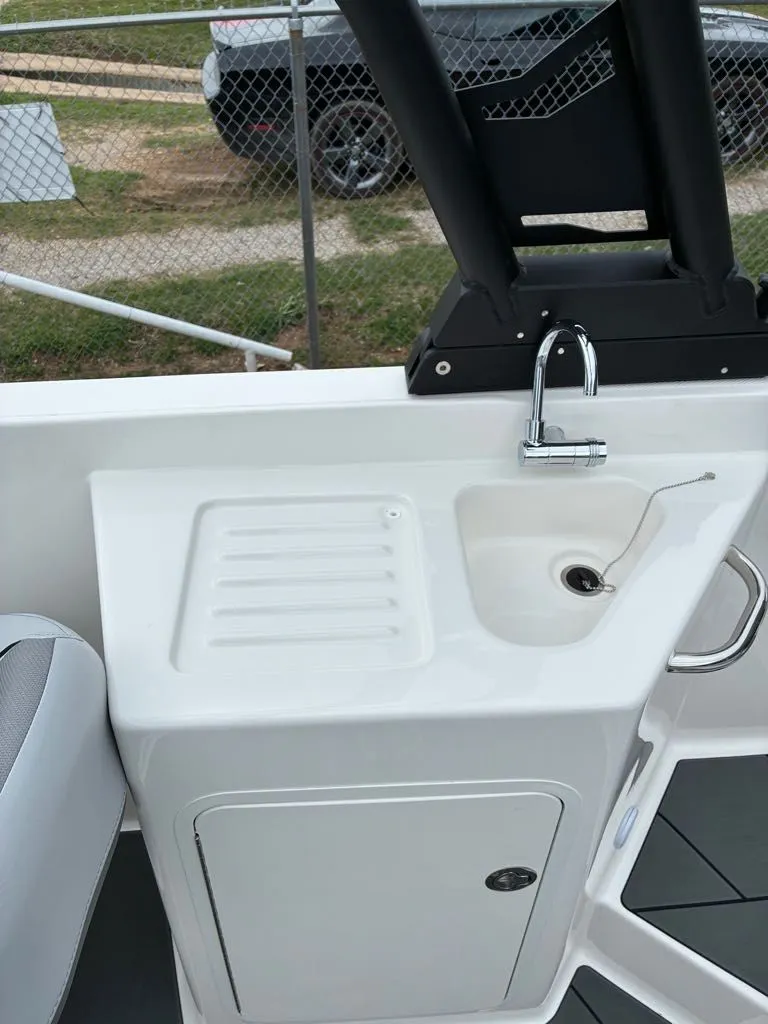 Slide: The Image of Bayliner D22 2026 boat kitchenette with sink and storage. - 4