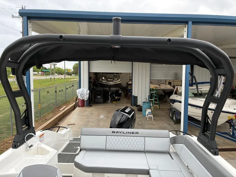 Slide: The Image of Bayliner D22 2026 boat in warehouse with black bimini top. - 7