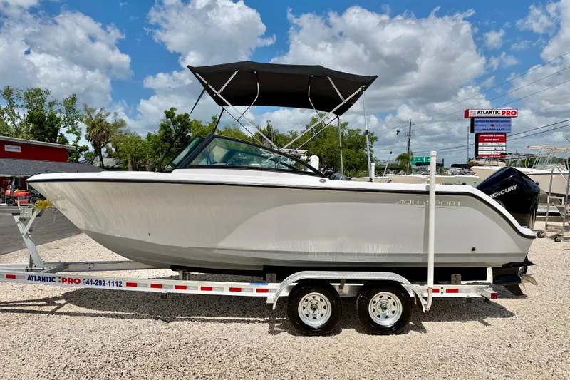 The Image of 2023 Aquasport 2200 Dual Console boat on trailer under blue sky. - 0