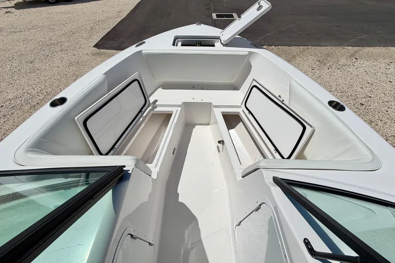 Slide: The Image of 2023 Aquasport 2200 Dual Console boat with open storage compartments and sleek design. - 12