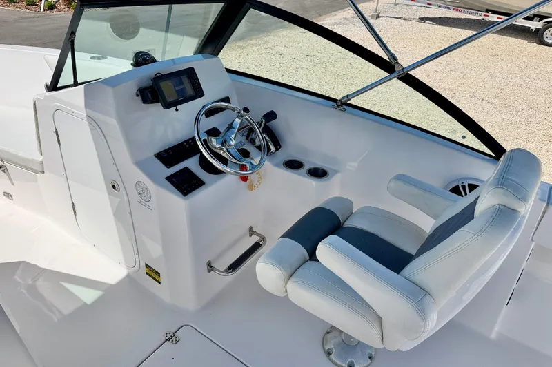 Slide: The Image of 2023 Aquasport 2200 Dual Console boat interior with steering wheel and captain's chair. - 13