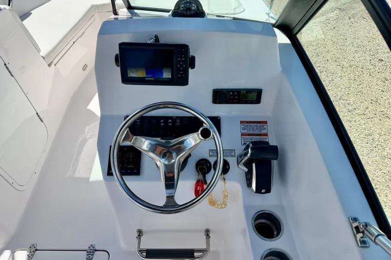 Slide: The Image of 2023 Aquasport 2200 Dual Console helm with steering wheel and navigation display. - 16