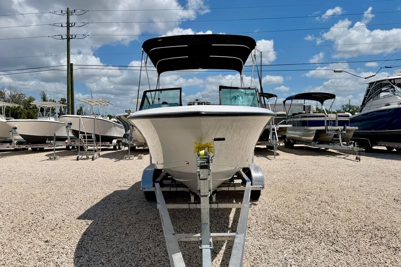 Slide: The Image of 2023 Aquasport 2200 Dual Console boat on trailer under blue sky. - 2