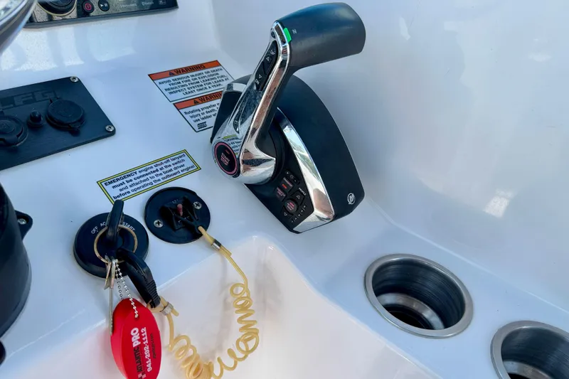 Slide: The Image of Control panel of 2023 Aquasport 2200 Dual Console boat with throttle and ignition keys. - 22