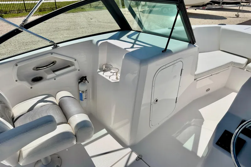 Slide: The Image of 2023 Aquasport 2200 Dual Console interior with seating, storage, and cup holders. - 23