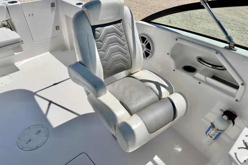 Slide: The Image of 2023 Aquasport 2200 Dual Console boat interior with cushioned seat and control panel. - 24