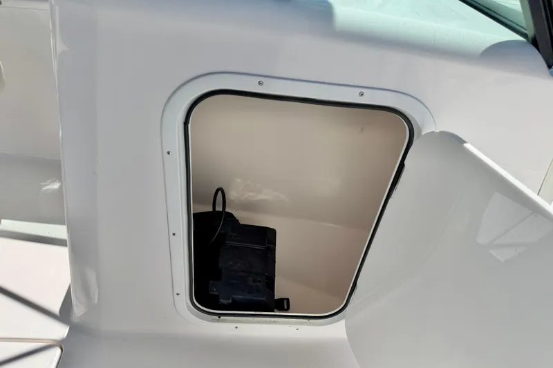 Slide: The Image of 2023 Aquasport 2200 Dual Console storage compartment with open hatch. - 30