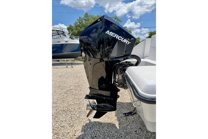 Slide: The Image of 2023 Aquasport 2200 Dual Console with Mercury outboard motor, parked on gravel. - 32