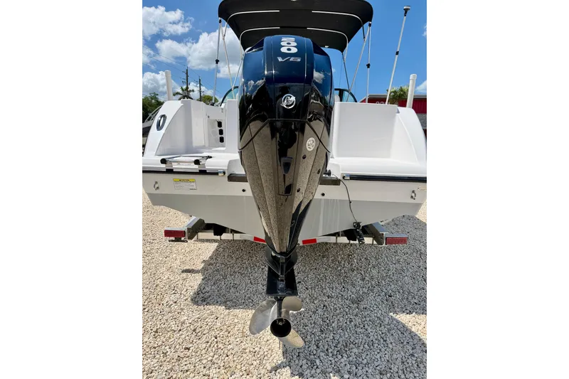 Slide: The Image of 2023 Aquasport 2200 Dual Console boat with powerful outboard motor, parked on gravel. - 33