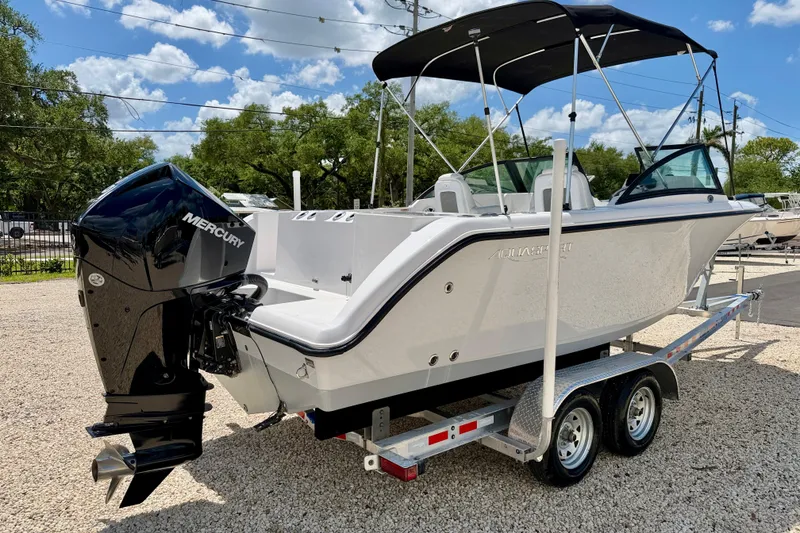 Slide: The Image of 2023 Aquasport 2200 Dual Console boat on trailer with Mercury engine, parked outdoors. - 5