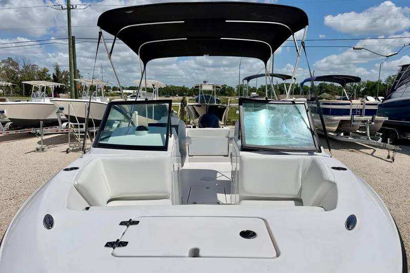 Slide: The Image of 2023 Aquasport 2200 Dual Console boat with canopy, displayed outdoors under a blue sky. - 9