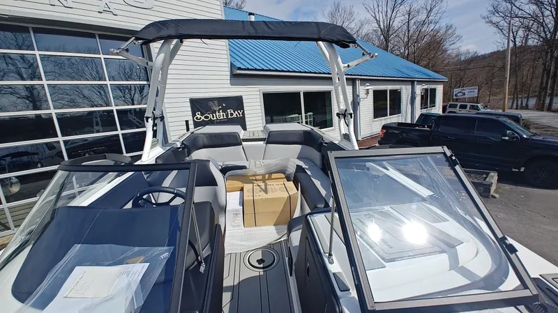 Slide: The Image of 2026 Moomba Max boat displayed outdoors at a dealership. - 10