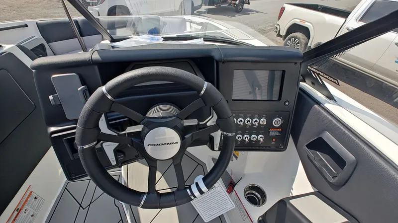 Slide: The Image of Interior view of 2026 Moomba Max boat cockpit with steering wheel and controls. - 12