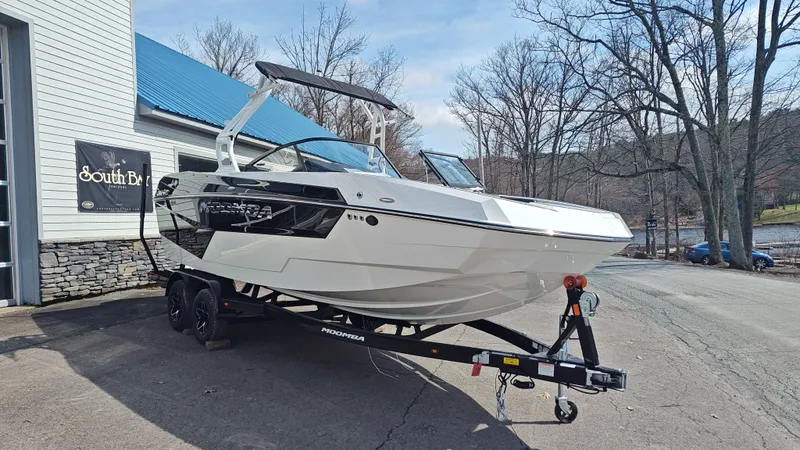 Slide: The Image of 2026 Moomba Max boat on trailer outside building. - 2
