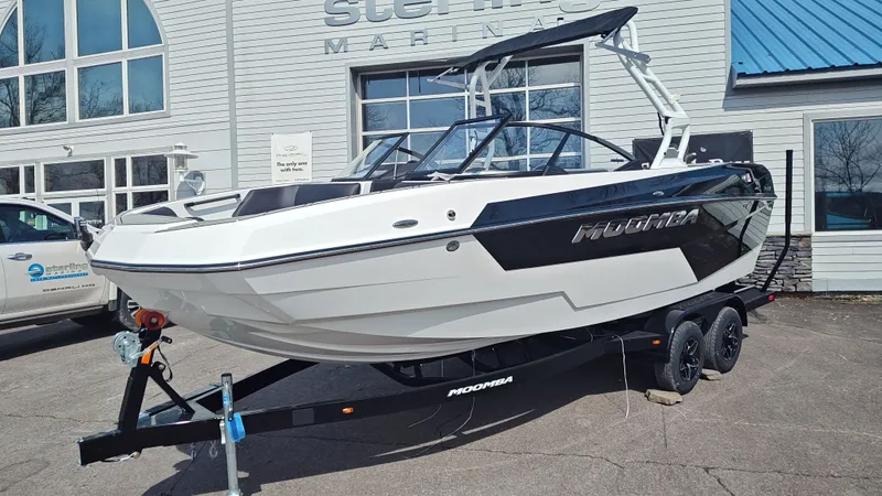 Slide: The Image of 2026 Moomba Max boat on trailer outside a building. - 3