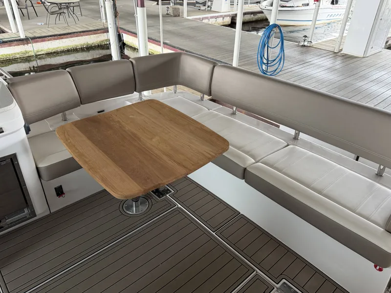 Slide: The Image of Interior of 2017 Regal 42 Grande Coupe with wooden table and seating area. - 17