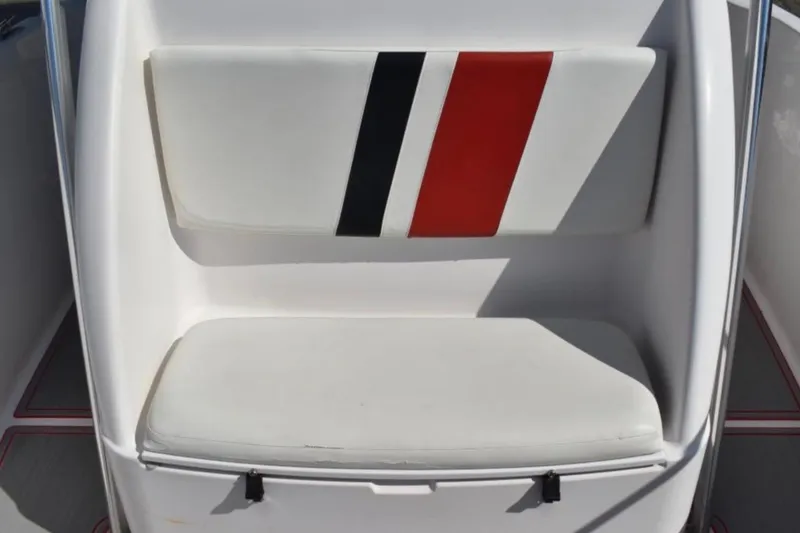Slide: The Image of White cushioned seat with red and black stripes on a 2001 Pro-Line 3400 Bimini Cuddy boat. - 12