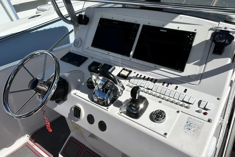 Slide: The Image of Helm of 2001 Pro-Line 3400 Bimini Cuddy with steering wheel and navigation controls. - 13