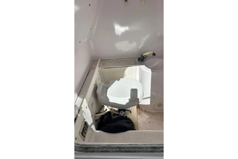 Slide: The Image of 2001 Pro-Line 3400 Bimini Cuddy boat interior with compact marine toilet. - 20