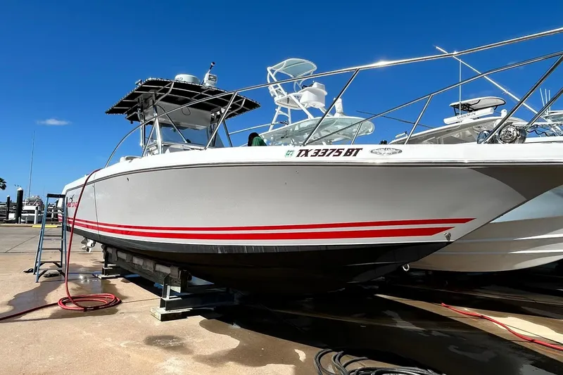 Slide: The Image of 2001 Pro-Line 3400 Bimini Cuddy boat on trailer, featuring sleek design and red stripes. - 3