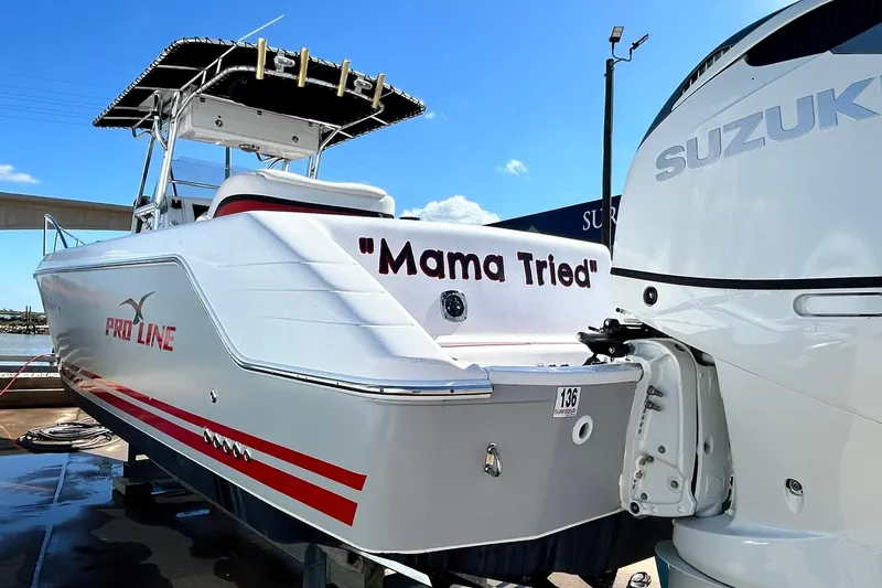 Slide: The Image of 2001 Pro-Line 3400 Bimini Cuddy boat with Suzuki engine, named "Mama Tried," docked under clear skies. - 5