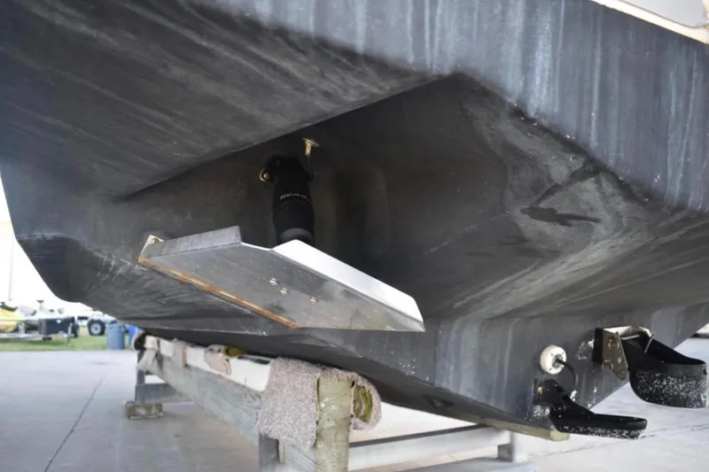 Slide: The Image of 2001 Pro-Line 3400 Bimini Cuddy boat hull detail with trim tab and fittings. - 6