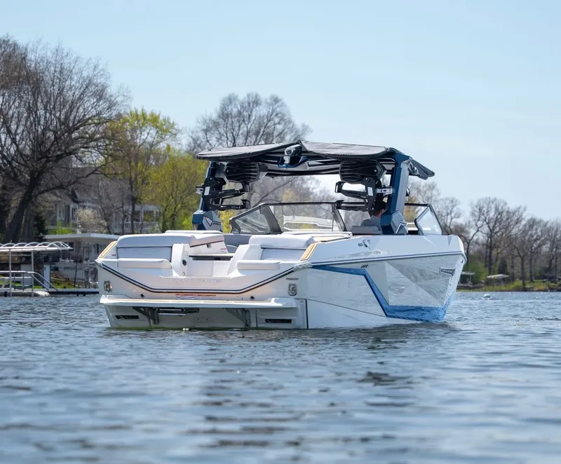 Slide: The Image of 2026 Nautique G25 boat on calm lake under clear sky. - 4