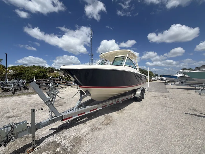 Slide: The Image of 2014 Pursuit DC 265 Dual Console boat on trailer under blue sky. - 10
