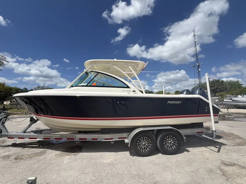 Slide: The Image of 2014 Pursuit DC 265 Dual Console boat on trailer, blue sky. - 4