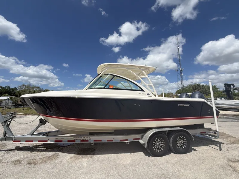 Slide: The Image of 2014 Pursuit DC 265 Dual Console boat on trailer under blue sky. - 9