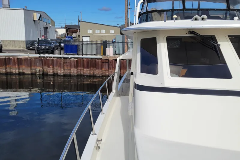 Slide: The Image of 1998 Tollycraft 65 Pilothouse yacht docked at an industrial waterfront. - 11